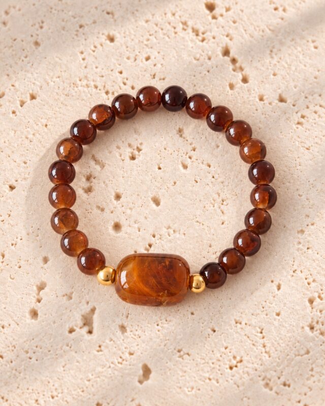 Armband bruin met ovale kraal op lichte natuurstenen plaat